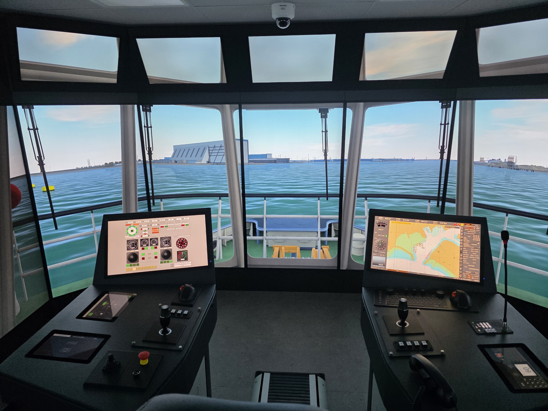 Full-mission simulator bridge with panoramic vessel displays and operational controls